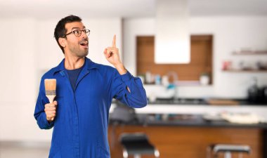 Ressam adam bir fikir evde parmak yukarı işaret düşünüyor