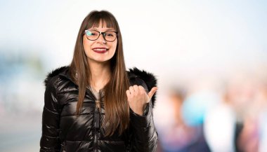 Açık havada bir ürün sunmak için yan işaret gözlük ile kadın