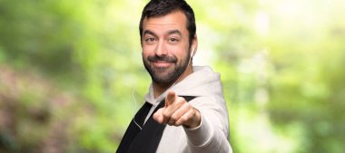 Spor adam bir parkta kendine güvenen bir ifade ile parmak puan