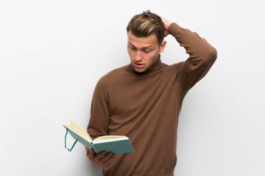 Bir kitap okuma zevk iken izole beyaz duvar üzerinde sarışın adam şaşırttı