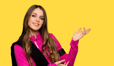 Genç spor kadın izole sarı arka plan üzerine gelmek için davet için yan eller uzanan