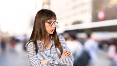 Açık havada ısırık dudak iken yüz ifadesi karıştırır ile gözlük kadın