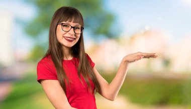 Açık havada bir reklam eklemek için boşaltmak tutan gözlük ile kadın