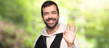 Bir parkta mutlu ifade ile el ile Saluting spor adam