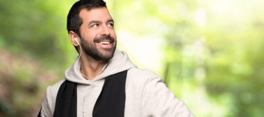 Spor adam kalça silah ile poz ve bir parkta gülüyor