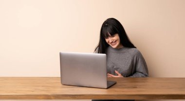 Çok gülümseyen onu laptop ile çalışan genç kadın