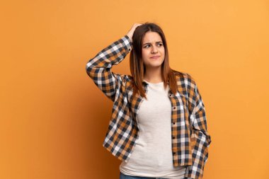 Kahverengi duvar üzerinde genç kadın kafa çizilirken şüphe sahip