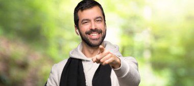 Spor adam bir parkta kendine güvenen bir ifade ile parmak puan