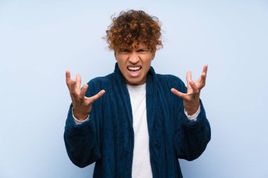 Pijamalı genç Afrikalı Amerikalı bir adam mutsuz ve hayal kırıklığına uğramış.