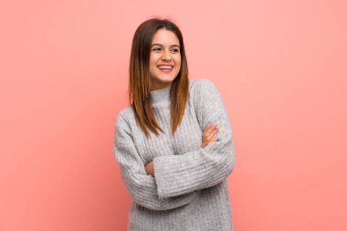 Gülümseyen süre pembe duvar üzerinde genç kadın bakıyor