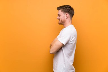 Yanal pozisyonda kahverengi duvar üzerinde Redhead adam