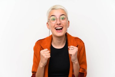 Beyaz duvar üzerinde kısa saçlı genç kız bir zafer kutluyor