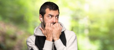 Spor adam biraz gergin ve bir parkta ağız eller koyarak korkuyor