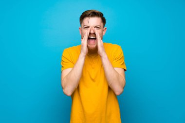 Mavi duvar üzerinde Redhead adam bağırıyor ve bir şey ilan