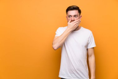 Elleri ile ağız kapsayan kahverengi duvar üzerinde Redhead adam