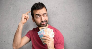 Adam çok para alarak şüphe sahip dokulu duvar üzerinde kafa çizilirken