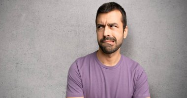 Dokulu duvar üzerinde ısırık dudak iken yüz ifadesi karıştırır ile yakışıklı adam