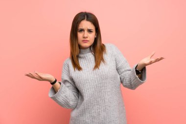 Pembe duvar üzerinde genç kadın bir şey anlamak için mutsuz