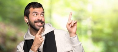 Spor adam indeks parmak ile işaret ve bir parkta bakıyor