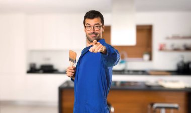 Ressam adam evde emin bir ifade ile parmak işaret