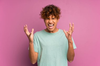 Genç Afrikalı Amerikalı bir adam, izole edilmiş mor bir duvarın üzerinde mutsuz ve hayal kırıklığına uğramış bir şekilde.