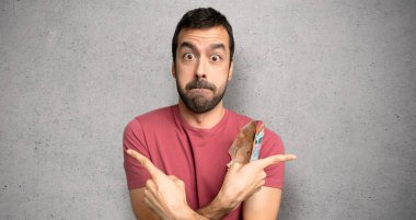 Adam lateraller dokulu duvar üzerinde şüpheler sahip işaret çok para alarak