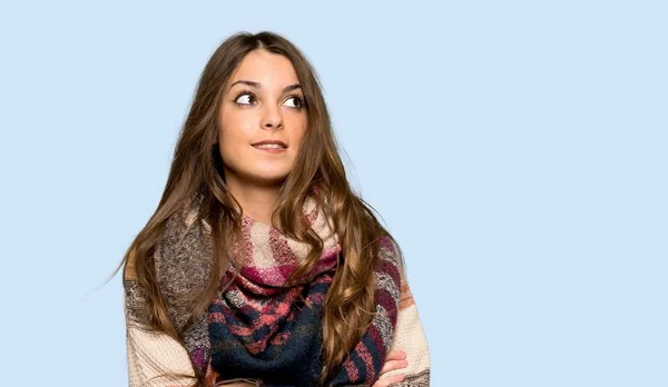 Young hippie woman with confuse face expression while bites lip over isolated blue background