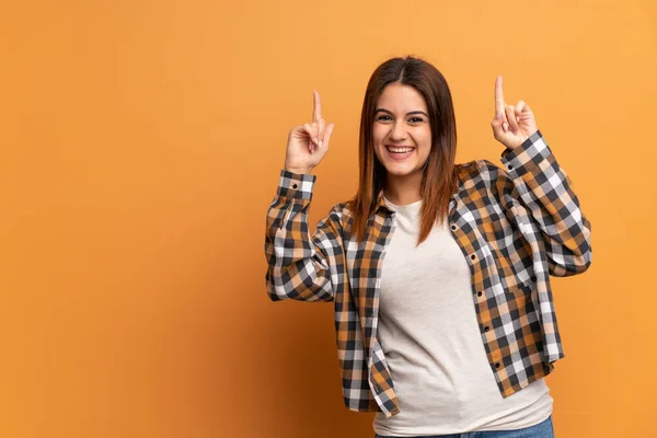 Jovem Mulher Sobre Parede Marrom Apontando Para Uma Grande Ideia — Fotografia de Stock