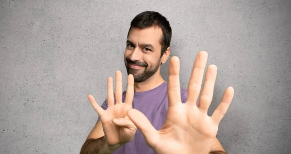 Handsome Man Counting Nine Fingers Textured Wall — Stock Photo, Image