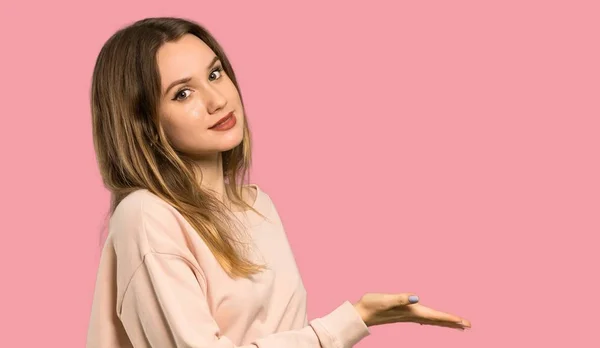 Adolescente Chica Con Suéter Rosa Que Presenta Una Idea Mientras —  Fotos de Stock