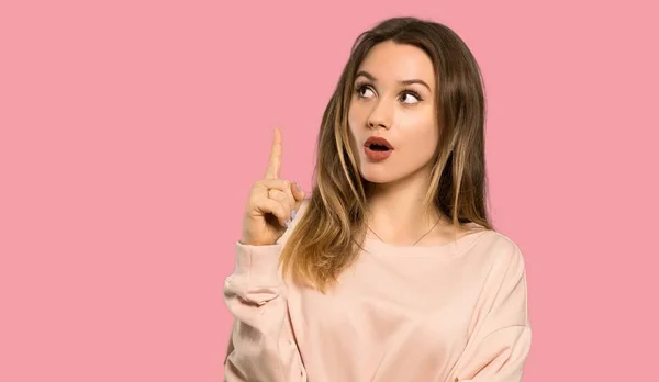 Teenagerka Růžovým Svetrem Uvažuje Nápad Ukazující Prstem Izolované Růžové Pozadí — Stock fotografie