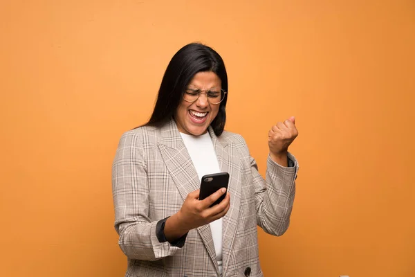 Joven Colombiana Sobre Pared Marrón Con Teléfono Posición Victoria — Foto de Stock