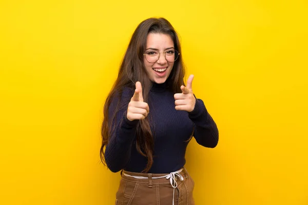 Teenager Girl Isolated Yellow Wall Pointing Front Smiling — Stock Photo, Image