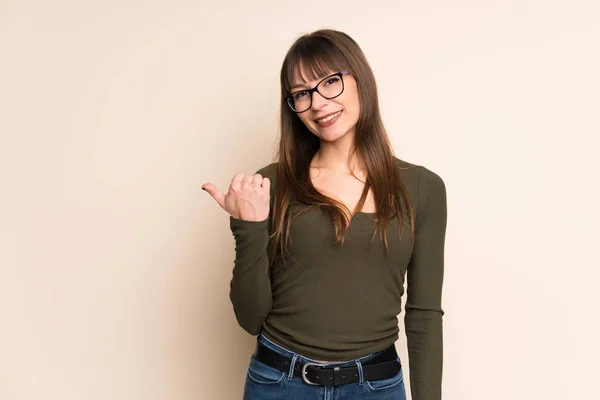 Mujer Joven Sobre Fondo Ocre Apuntando Hacia Lado Para Presentar — Foto de Stock