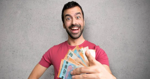 İnsan dokulu duvar üzerinde emin bir ifade ile para puan parmağı çok alarak