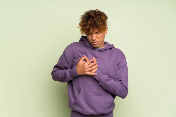 Young African American Man Isolated Green Wall Having Pain Heart — Stock Photo, Image