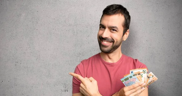 Adam dokulu duvar üzerinde bir ürün sunmak için yan işaret çok para alarak