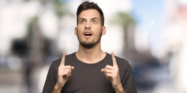 Man Black Shirt Surprised Pointing Outdoors — Stock Photo, Image