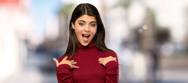 Teenager girl with turtleneck with surprise facial expression at outdoors