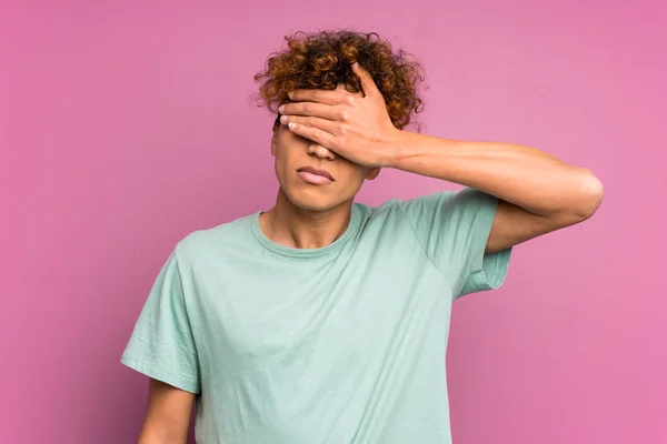 Young african american man over isolated purple wall covering eyes by hands