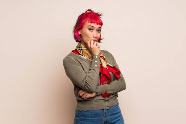 Şaşırttı ve doğru bakarken şok sarı duvarın üzerinden pembe saçlı genç kadın