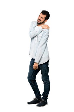 Tam uzunlukta çekim için bir çaba izole beyaz arka plan üzerinde yapılmış olan omuz ağrısı muzdarip sakallı yakışıklı adam