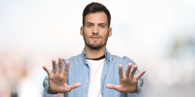 Yakışıklı adam on açık havada ince ve sert parmaklar ile sayma