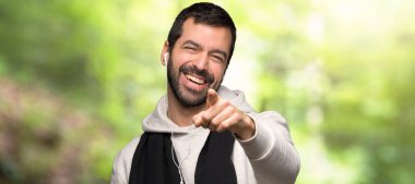 Spor adam parmak biriyle işaret ve bir parkta çok gülüyor