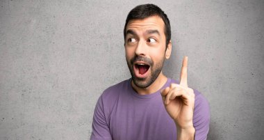 Yakışıklı adam bir fikir dokulu duvar üzerinde parmak işaret düşünme