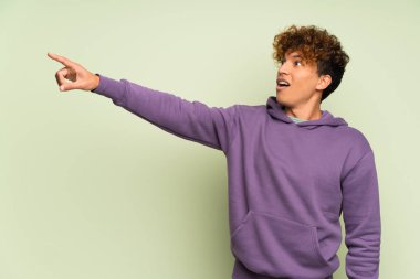 İzole edilmiş yeşil duvarın üzerindeki genç Afro-Amerikan adam