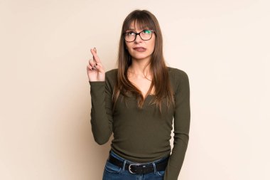 En iyi dilek ve geçiş parmakları koyu sarı zemin üzerine genç kadın