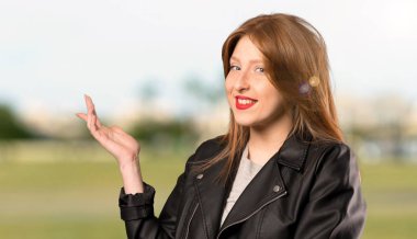 Genç Redhead kadın açık havada gelmek için davet için yan eller uzanan