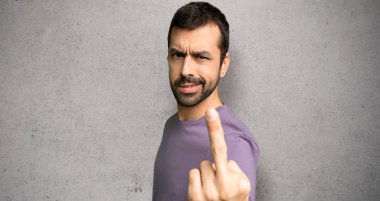 Dokulu duvar üzerinde boynuz jest yapma yakışıklı adam