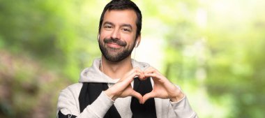 Spor adam bir parkta eller tarafından kalp sembolü yapma